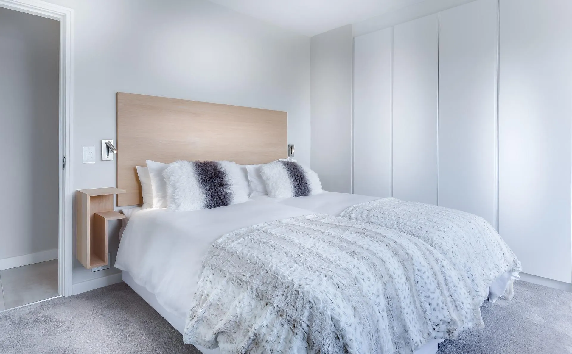 A holiday-rental bedroom with a freshly made bed in crisp white linen